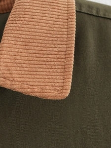 Detail view showing olive green canvas fabric with a contrast brick red corduroy collar