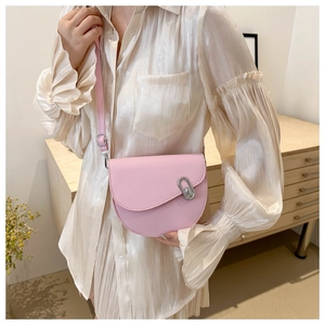 Detail of pink saddle bag featuring silver runway buckle and adjustable strap hardware