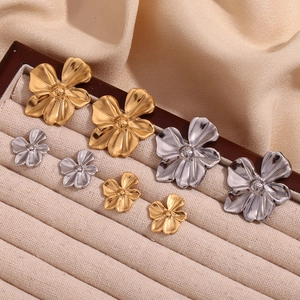 Selection of gold and silver flower stud earrings in large and small sizes on a velvet tray