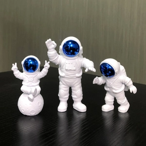 Detailed trio of white astronaut figurines with blue visors in various poses on dark surface