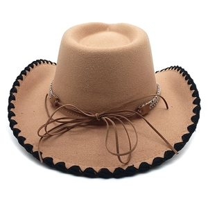 Detail of tan felt cowboy hat featuring black contrast stitching on the wide brim edges