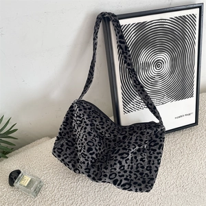 Detail of grey leopard print tote bag with soft velvet texture and brand side label