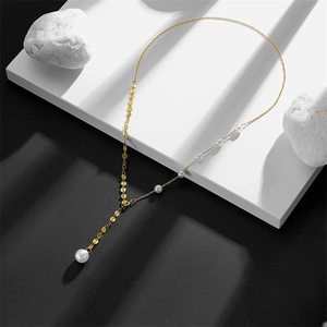 Artistic close-up of a gold double-layer pearl necklace with a stylish Y-chain design