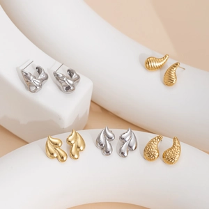 Collection of modern titanium steel earrings in gold and silver with textured floral designs