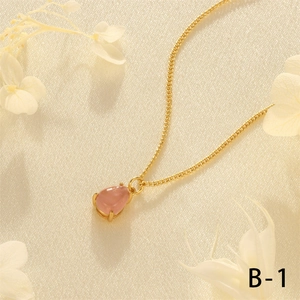 Detail view of pink teardrop gemstone pendant on a fine 18K gold plated Cuban chain