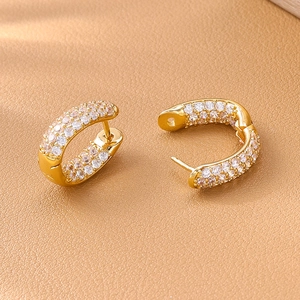 Eleganti orecchini a cerchio a U placcati in oro con zirconi cubici su pelle marrone