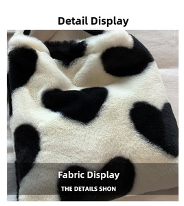 Close-up of soft faux fur tote bag showing plush black and white heart pattern texture