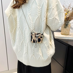 Mini leopard print crossbody bag with metal chain shown worn over a white knit sweater