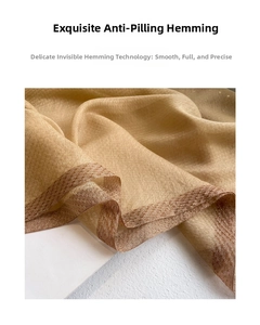 Detail of silk wool shawl showing fine seamless hem edges and luxury champagne gold texture