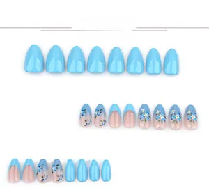 Detailed view of blue gradient press-on nails with delicate floral patterns and glossy finish