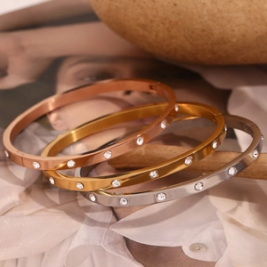 Close-up of three-color 18K gold plated bangles with inlaid round zircon gemstones