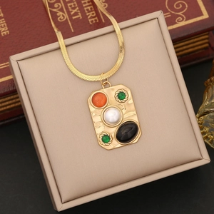 Macro shot of vintage gold turquoise necklace with pearl and colorful gems on jewelry box