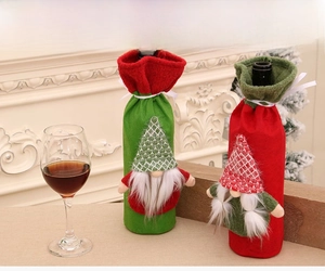 Detail of red and green Christmas gnome wine bottle covers with plaid hats and white beards