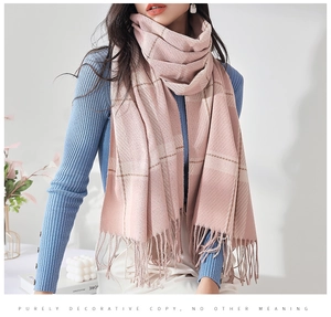 Gros plan d'une écharpe à carreaux rose avec des pompons doux et un tissage de qualité