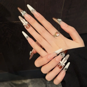 Brown and white stiletto press-on nails with silver bows, pearls and glitter accents