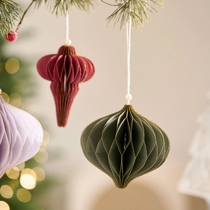 Honeycomb paper Christmas ornaments with gold glitter edges and pearl beads hanging in trio