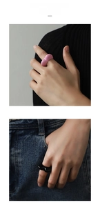 Close-up of chunky pink and black enamel heart rings worn on a model's hand