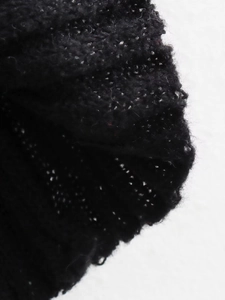 Close-up macro view of the black knitted fabric texture and fine ribbed details on a dress