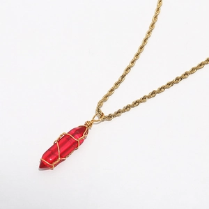 Macro shot of red hexagonal crystal pendant with gold wire wrap on a twisted rope chain