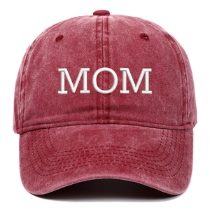 Close-up detail of white MOM embroidery on vintage washed red cotton baseball cap