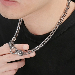 Close-up of men's chunky silver chain necklace featuring a detailed lion head clasp