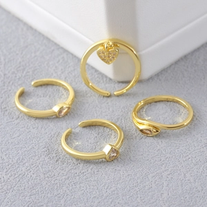 Ensemble de bagues dorées avec zircons cœur et goutte d'eau sur support à bijoux chic