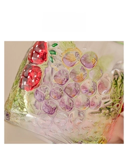 Detailed macro view of hand-painted grape and strawberry relief on glass coffee mug