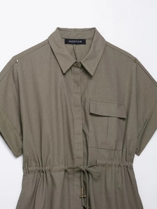Detail of army green utility shirt fabric featuring drawstring waist and chest pocket