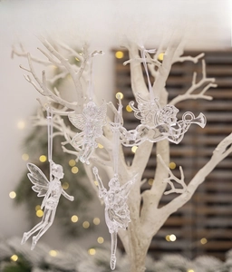Iridescent acrylic Christmas angel ornaments hanging on white branches with bokeh lights