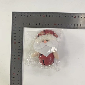 Detailed view of Santa Claus bell ornament measured on a ruler for size scale