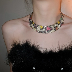Detailed close-up of a wide gold choker featuring vibrant multi-color leopard rhinestone patterns