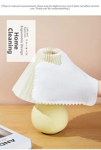 Close-up of white honeycomb textured cleaning glove dusting a yellow pleated lampshade