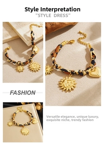 Macro detail of leopard print fabric strap and golden engraved sun heart charms on bracelet