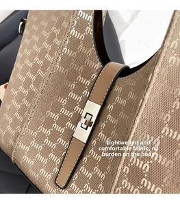 Detail of jacquard fabric texture and silver metal buckle on a beige shoulder bag