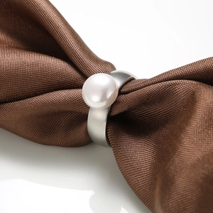 Detailed close-up of a silver stainless steel ring with a large white pearl inlay