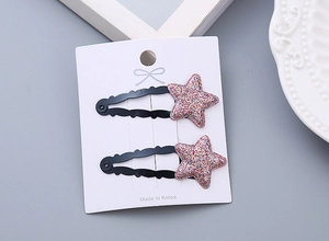Close-up of glitter star hair clips for girls set on a white card with Korean text