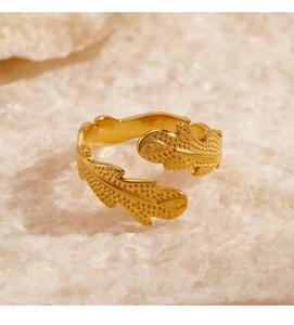 Detail of golden adjustable leaf ring with textured surface on mineral stone background
