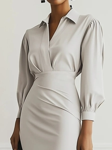 Detail eines eleganten hellgrauen Satin-V-Kleides mit Taillenfaltung und Puffärmeln