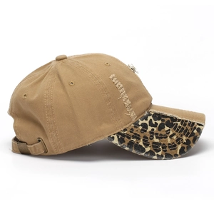 Close-up of distressed cotton baseball cap with leopard print brim and metal buckle