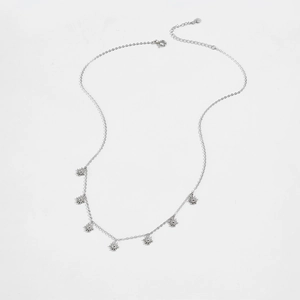 Macro view of sterling silver necklace with multiple sunburst pendants and fine link chain