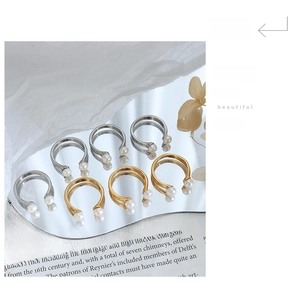 Detailed set of U-shaped gold and silver rings with pearls on elegant magazine background