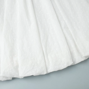 Κοντινό πλάνο σε λευκό ύφασμα broderie anglaise με περίπλοκα φλοράλ κεντητά σχέδια και οπές