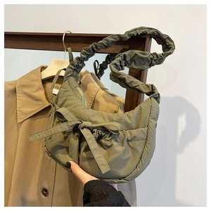 Detail of olive green ruched shoulder bag with bow and scrunchie strap nylon texture