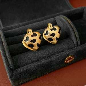 Detail of vintage heart-shaped leopard print earrings in a black velvet jewelry box