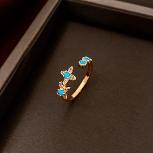 Macro detail of a gold plated flower ring featuring turquoise and zircon in a gift box