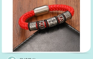 Détail d'un bracelet en cuir tressé rouge avec perles métalliques sur un portefeuille