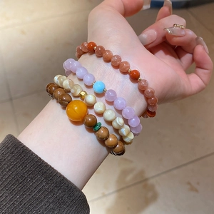 Detail of layered beaded bracelets with natural stones and Kuka shell on a wrist