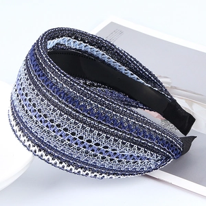 Wide woven headband for women in blue and white mesh fabric on a decorative plate