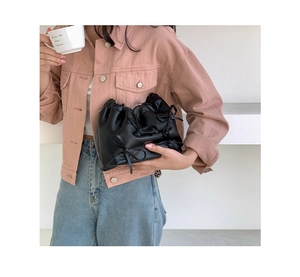 Detail of black pleated PU leather shoulder bag featuring delicate decorative bows