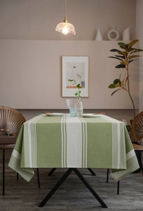 Detailed texture of green and white striped linen tablecloth in a cozy dining setting